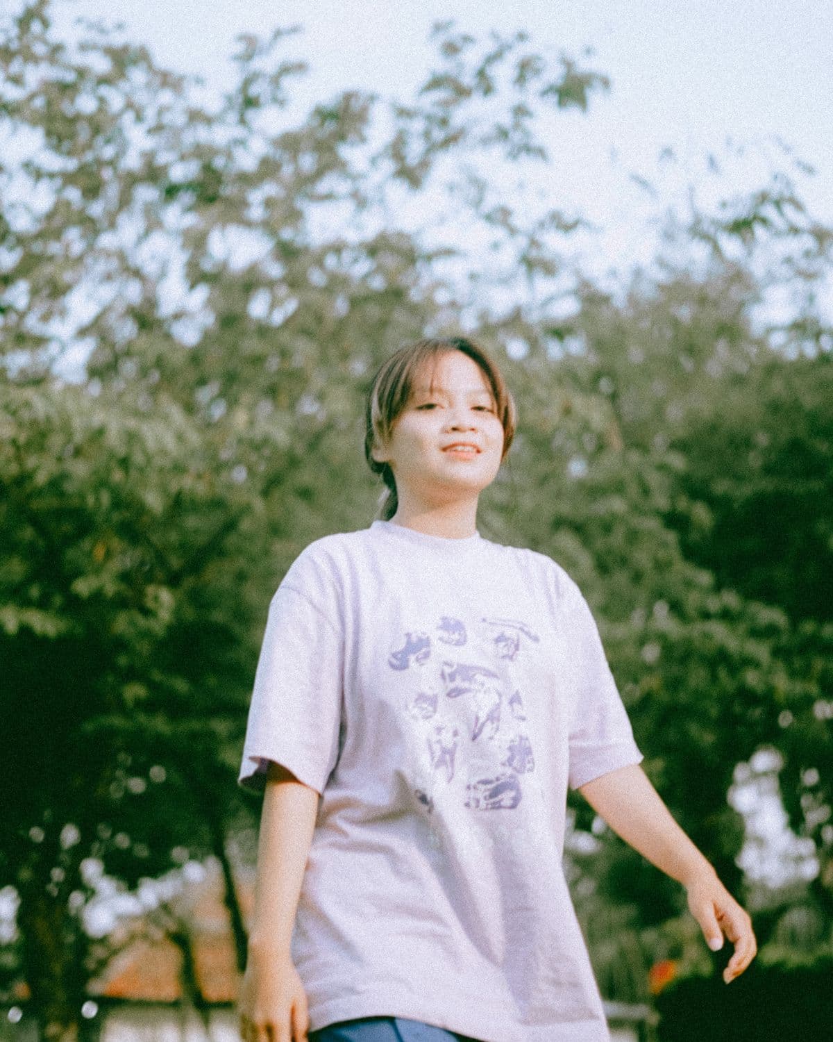 Model wearing a printed Threads by RZN tee outdoors